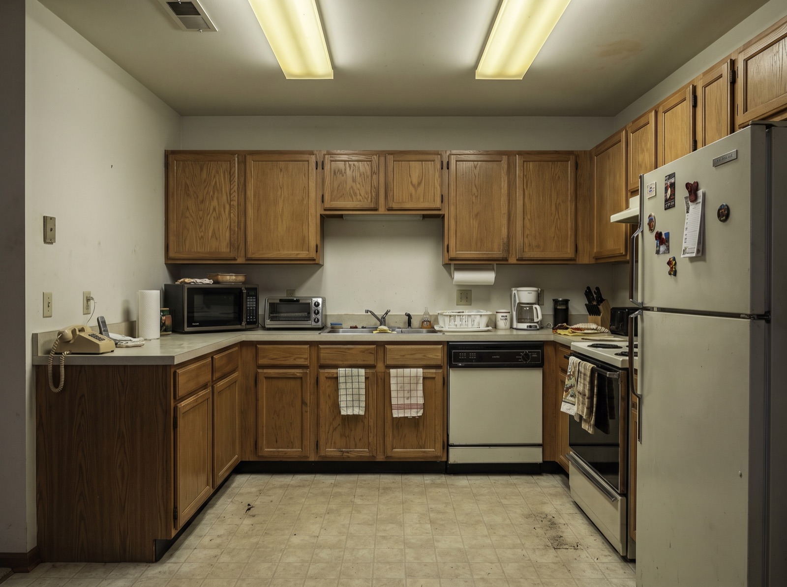 Dated kitchen before renovation: worn laminate counters and faded cabinetry